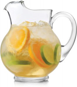 glass pitcheer will iced tea and sliced citrus fruits 